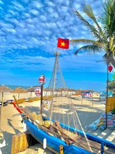 un barco en la playa con una bandera. en Hien Hoa Villa Hoi An, en Hoi An