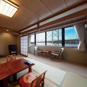 a living room with a table and chairs and a bridge at Naruto Kaigetsu in Naruto