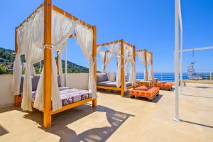 a bedroom with four beds and the ocean in the background at Highclere Hotel and Spa in Faralya