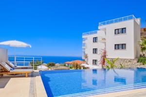 a villa with a swimming pool in front of a building at Highclere Hotel and Spa in Faralya