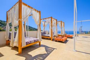 a room with four beds and the ocean in the background at Highclere Hotel and Spa in Faralya