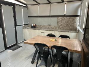 kuchnia z drewnianym stołem i czarnymi krzesłami w obiekcie la maison des sables 4 port Leucate climatisé parking privé w mieście Port Leucate