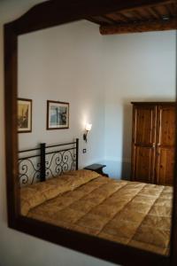 a mirror reflecting a bed in a bedroom at Villa Nottola in Montepulciano