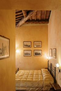 a bedroom with a bed and pictures on the wall at Villa Nottola in Montepulciano