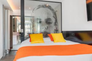 a bedroom with a large bed with two yellow pillows at Village Naturiste R4N - Le Xillion Port Nature in Cap d'Agde