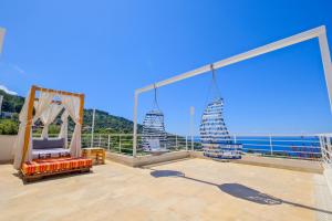 a balcony with a swing and a view of the ocean at Highclere Hotel and Spa in Faralya