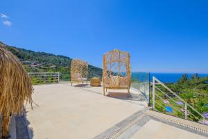 a patio with two chairs and the ocean in the background at Highclere Hotel and Spa in Faralya
