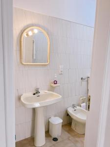 a bathroom with a sink and a mirror and a toilet at Mira Sol - Silhueta Citadina in Portimão