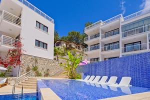 a villa with a swimming pool next to a building at Highclere Hotel and Spa in Faralya