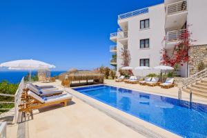 a villa with a swimming pool and a view of the ocean at Highclere Hotel and Spa in Faralya
