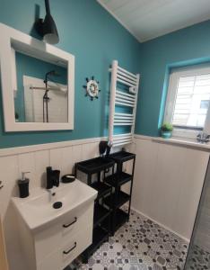 a bathroom with a white sink and blue walls at Plażowisko in Dębki +40 photos