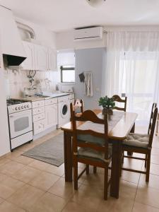 a kitchen with a table and chairs and a stove at Mira Sol - Silhueta Citadina in Portimão