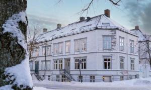 un gran edificio blanco con nieve. en Home away from home in Trondheim, en Trondheim