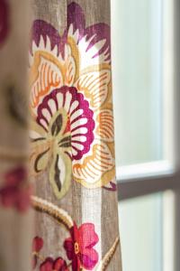 a curtain with a flower design on a window at Garlande Hôtel Avignon Centre in Avignon