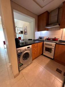 a kitchen with a washing machine and a dishwasher at Cosy home near metro station in Dubai