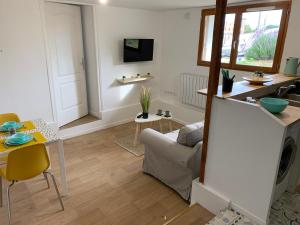 a living room with a couch and a table at Logement à 20 min de Paris avec parking gratuit in Eaubonne