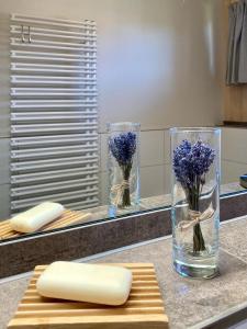 a counter with two glass vases with flowers in them at Ferienhaus LebenPUR Bio-Ferienhaus aus Holz in Parin
