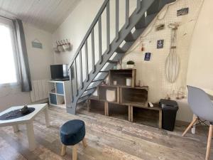 sala de estar con escalera, mesa y sillas en Appartement Noirmoutier-en-l'Île, 1 pièce, 4 personnes - FR-1-224B-99, en Noirmoutier-en-l'Île