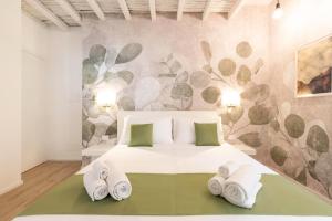 a bedroom with a white bed with towels on it at Metropolitan Rooms in Cagliari