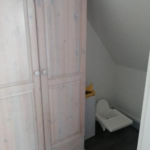 a white closet with a toilet in a room at Ferienwohnung Leuchtturmkieker in Schlagsdorf auf Fehmarn in Fehmarn