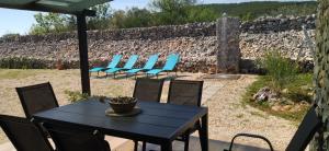 a black table and chairs and a stone wall at House for rest Juricev in Vodice