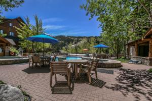 a patio with tables and umbrellas and a pool at Dakota Lodge 8455 in Keystone