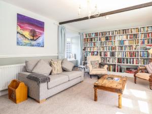 un soggiorno con divano, sedie e librerie di West Farm Cottage a Morpeth
