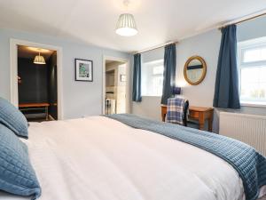 a bedroom with a large white bed and a desk at West Farm Cottage in Morpeth