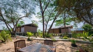 un resort con tavolo, sedie e alberi di Elephant View Camp a Ban Huai Thawai