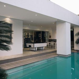 a swimming pool in a house with a bathtub at Poolside Villa in Johannesburg