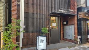 un edificio con una señal delante de una puerta en Guest House Tokyo Samurai, en Tokio