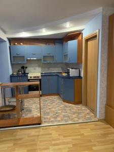 uma cozinha com armários azuis e piso em madeira em Затишна квартира на бульварі Свободи 49 ЖОВТІ ВОДИ em Zhovti Vody