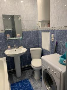 uma casa de banho com um WC, um lavatório e uma máquina de lavar roupa em Затишна квартира на бульварі Свободи 49 ЖОВТІ ВОДИ em Zhovti Vody