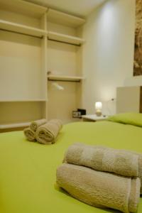 Un dormitorio con una cama verde con toallas. en Como Lake Crispi 7 Apartment, en Como