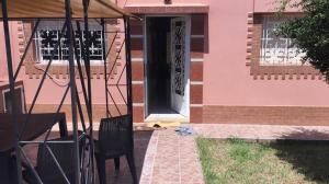 a pink house with a door and chairs in front at Villa à la compagne in Mohammedia