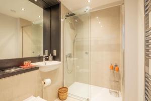 uma casa de banho com uma cabina de duche em vidro e um lavatório. em Luxury Ensuite Room 2 Minutes from Cambridge Station em Cambridge