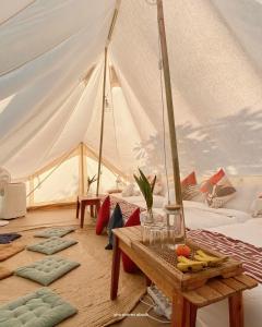 Zimmer mit einem Zelt mit einem Tisch in der Unterkunft Kalika Balayan in Balayan