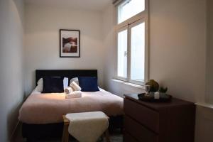 a bedroom with a bed with blue pillows and a window at Rembrandtplein Apartments in Amsterdam