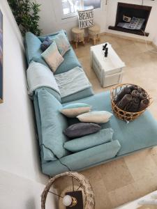 Sofá azul sentado en una sala de estar con almohadas en Casa de Almano - Torremolinos direct on beach, en Torremolinos