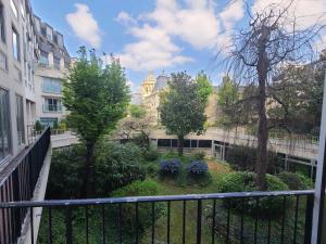 パリにあるAppartement de Charme Paris Centreの建物の前に庭園があるバルコニー