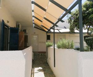 a pergola on the side of a house at Perdika Mare Guesthouse in Perdika
