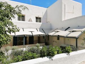 a building with a bunch of white umbrellas at Perdika Mare Guesthouse in Perdika