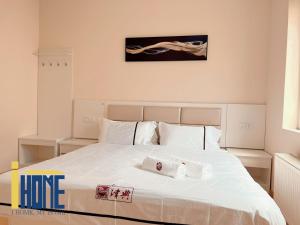 a bedroom with a large white bed with two towels on it at Ammo Glyfada Residences in Athens