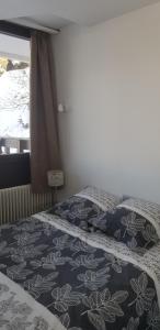 sypialnia z łóżkiem z czarno-białą narzutą w obiekcie Appartement 2 chambres 5/7 pers proche centre commercial avec piscine w mieście Chamrousse