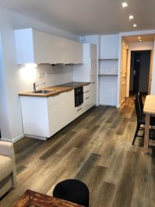 kuchnia z białymi szafkami, stołem i krzesłami w obiekcie Appartement 2 chambres 5/7 pers proche centre commercial avec piscine w mieście Chamrousse