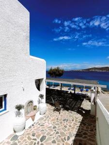 un edificio blanco con vistas al agua en Perdika Mare Guesthouse, en Perdika