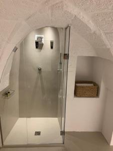 szklany prysznic w białym pokoju z koszem w obiekcie Boutique Room One w mieście Fasano