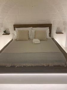 Una gran cama blanca con almohadas en un dormitorio. en Boutique Room One, en Fasano