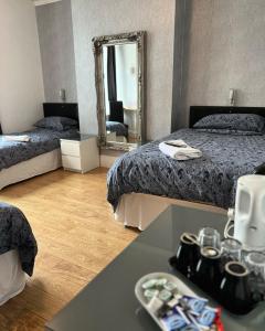 a hotel room with two beds and a mirror at Mayfair Guest House in Cardiff