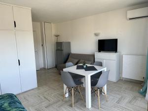 ein Wohnzimmer mit einem weißen Tisch und Stühlen in der Unterkunft vue marina et vue montagne in Mandelieu-la-Napoule